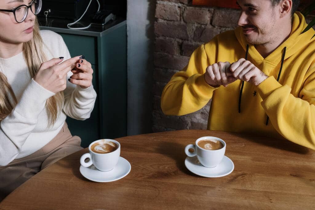 personas sordas tomando cafe